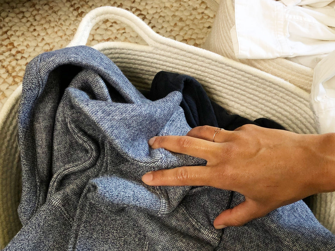 Grabbing a blue sweatshirt from a laundry basket