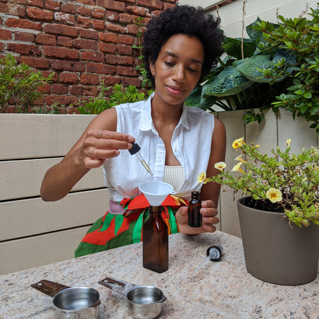 Corinna Williams adds essential oil to a spray bottle