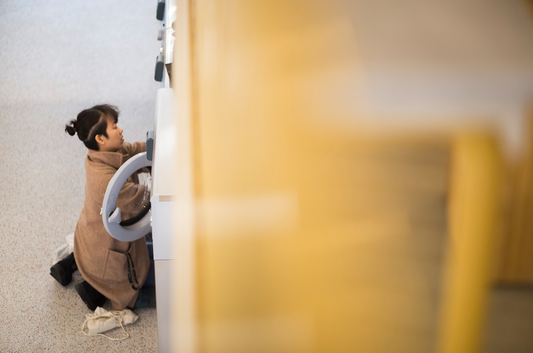 A person kneels to load laundry in a washer