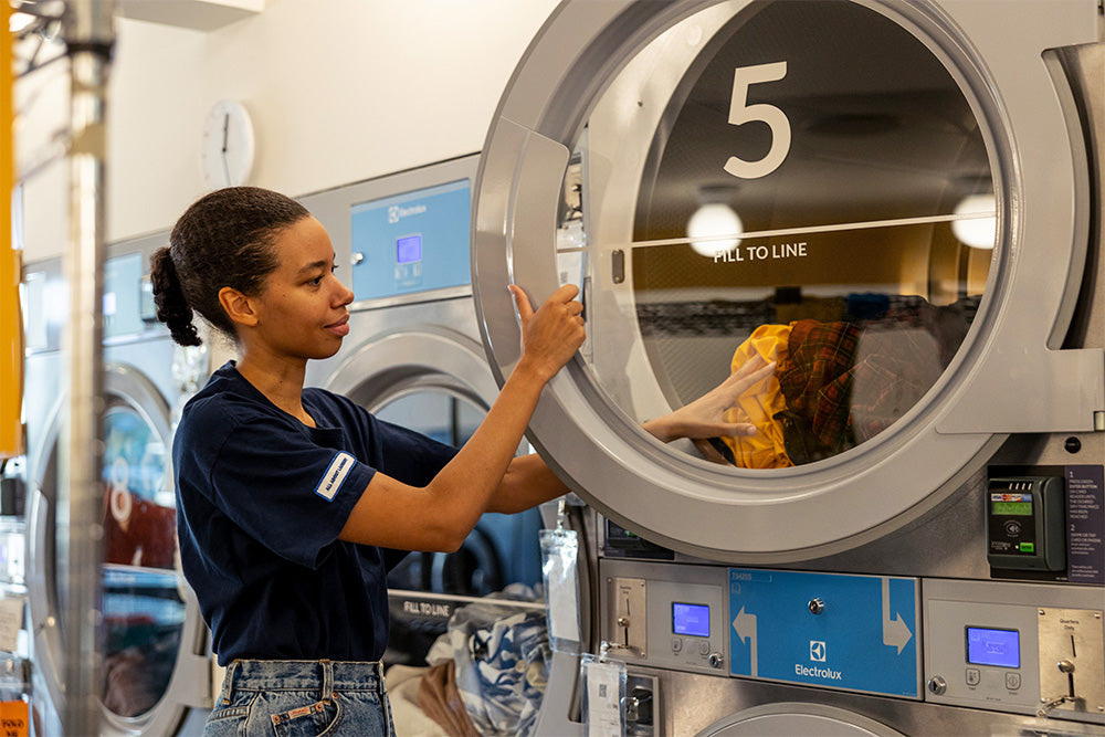Theresa Williams opens dryer number 5 at her laundromat Celsious