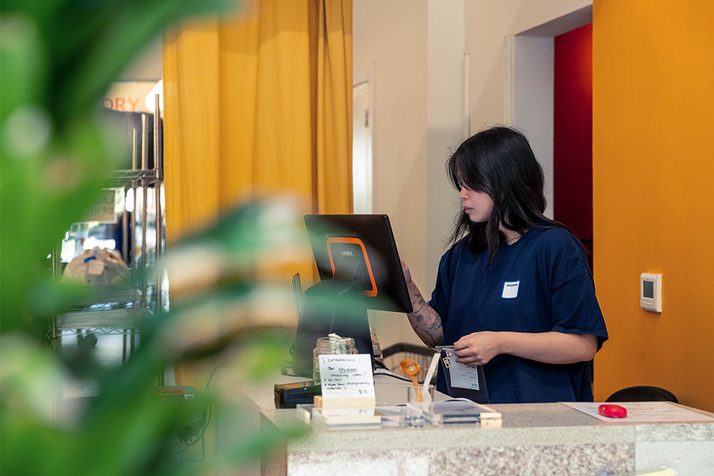 A young woman taps on a point-of-sale touchscreen