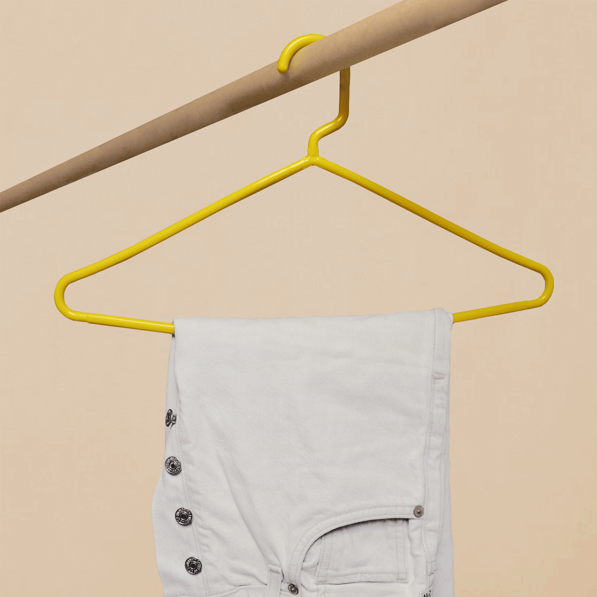 A high quality yellow hanger replaces a low quality hanger that bends under the weight of jeans