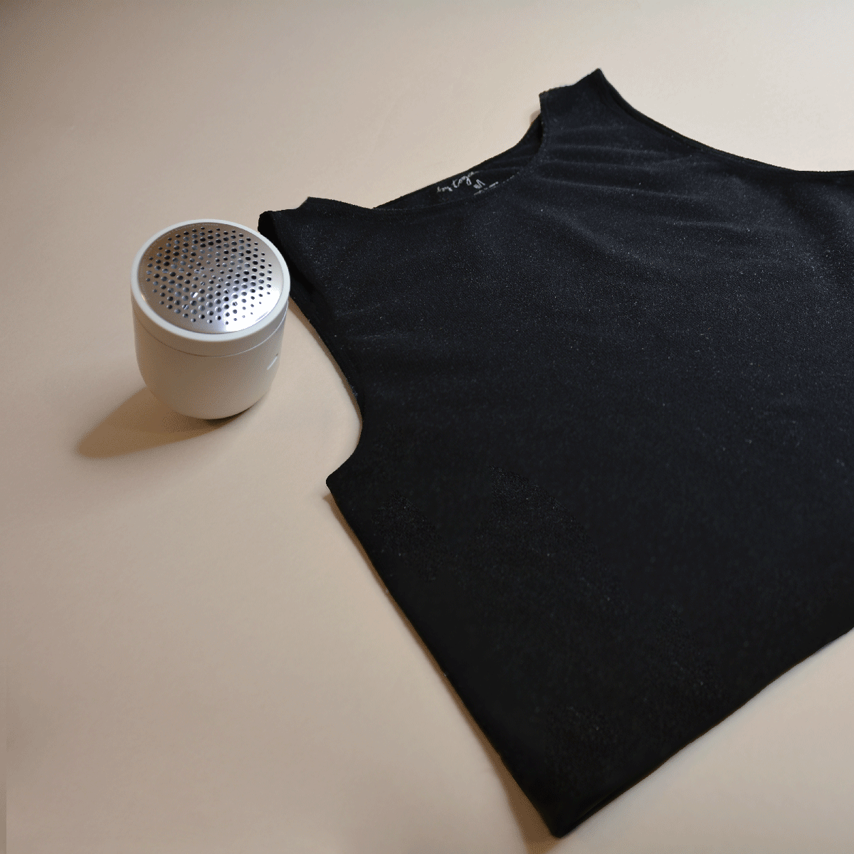 Before and after of a tank top that has been cleaned up with a fabric shaver