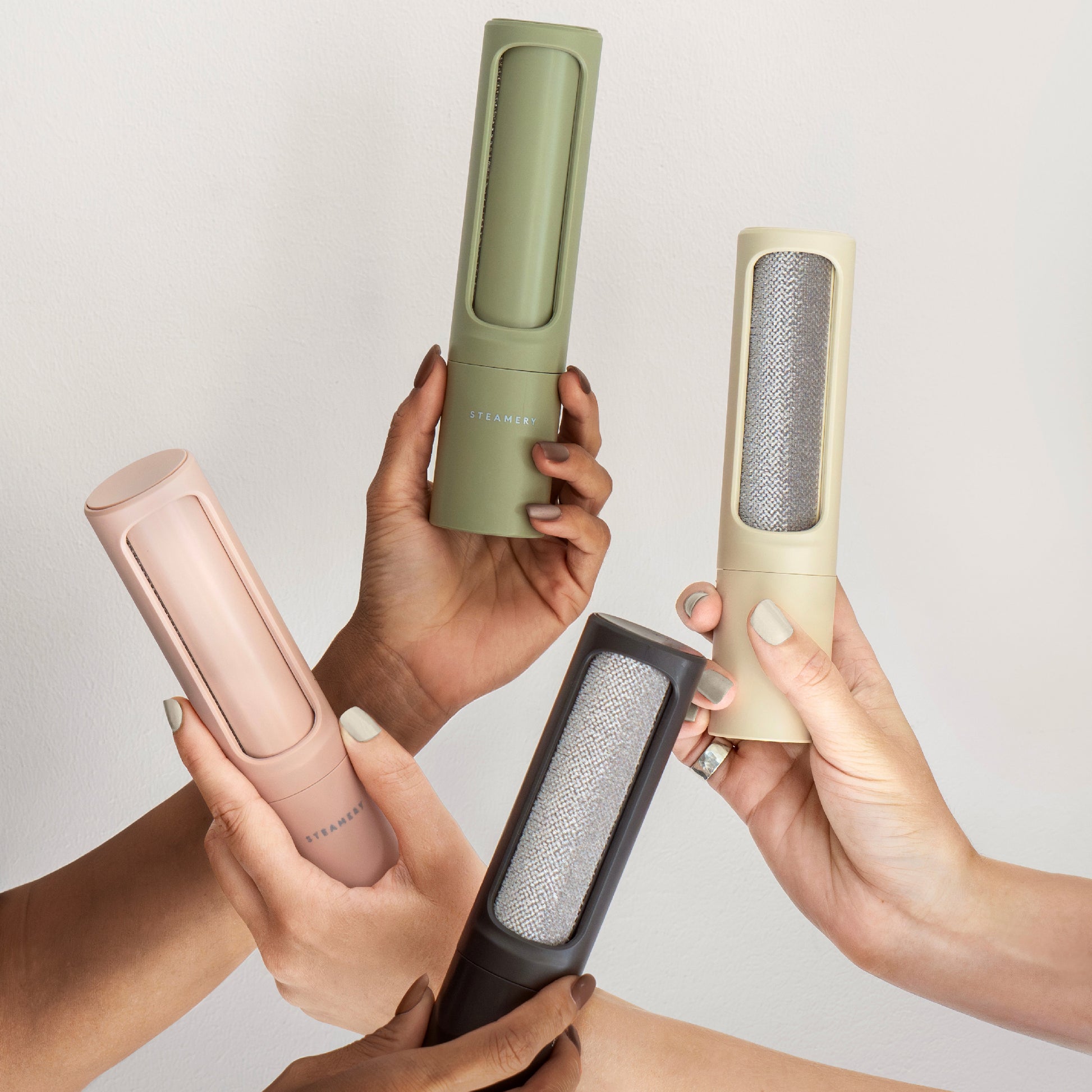 Steamery's reusable lint remover in four chic colors held by manicured hands