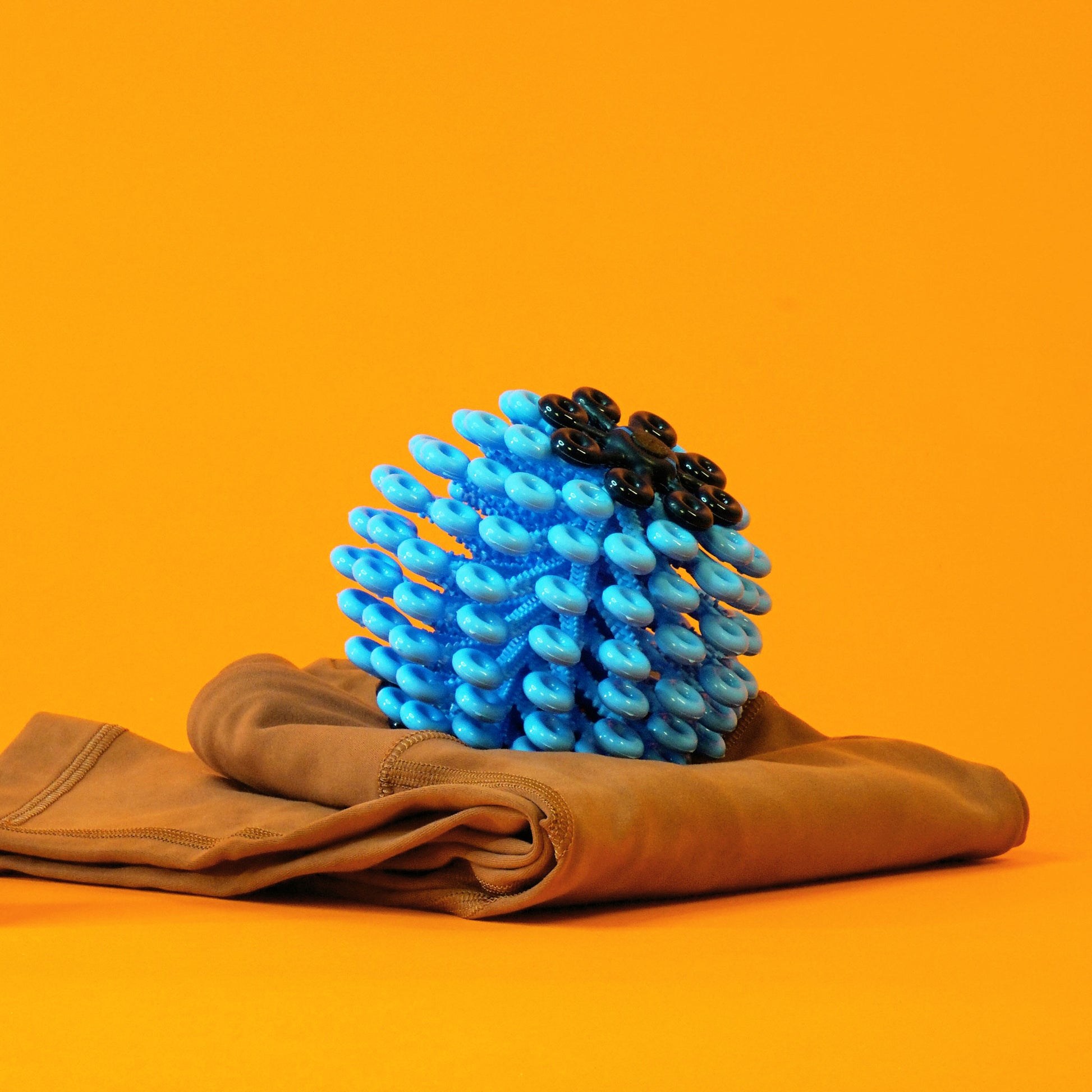 A blue Cora Ball on top of a folded pair of yoga leggings