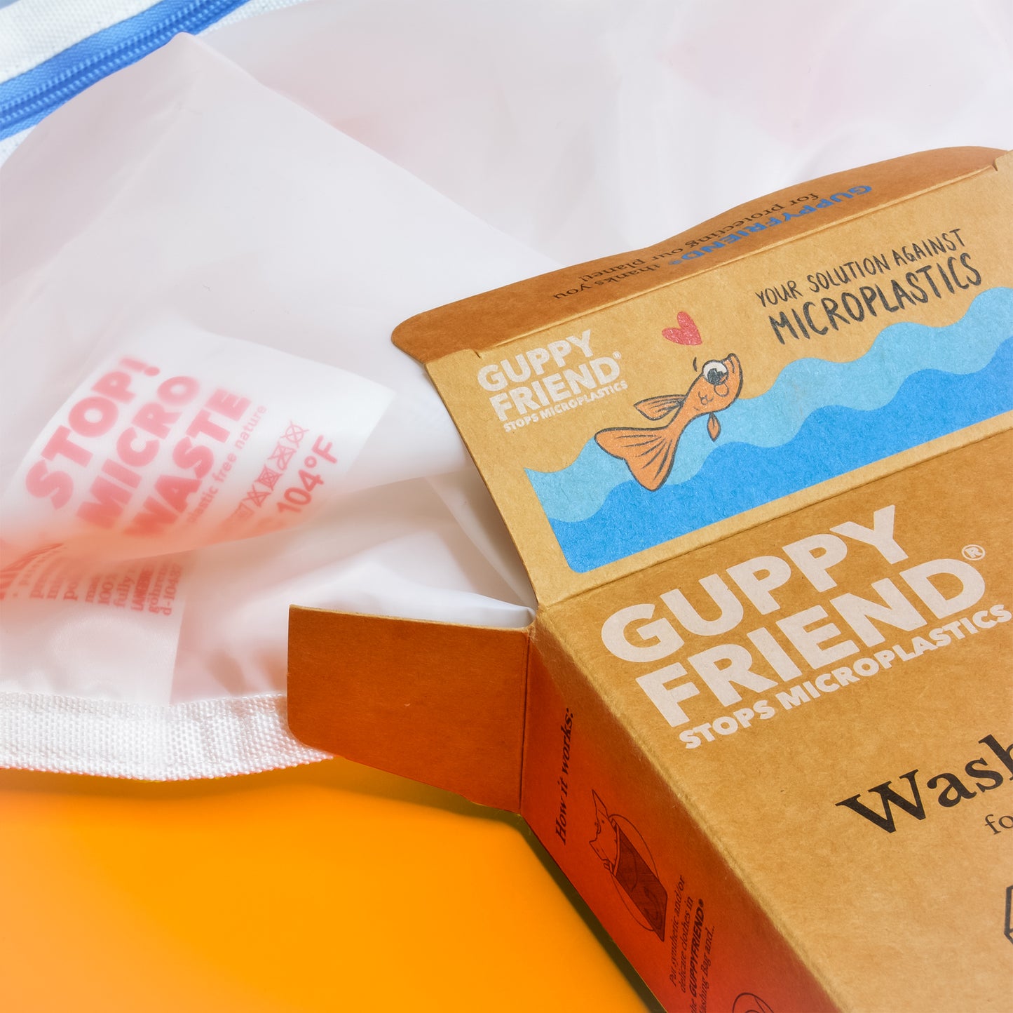 A close up of Guppyfriend packaging showing a fish and the words "your solution against microplastics"