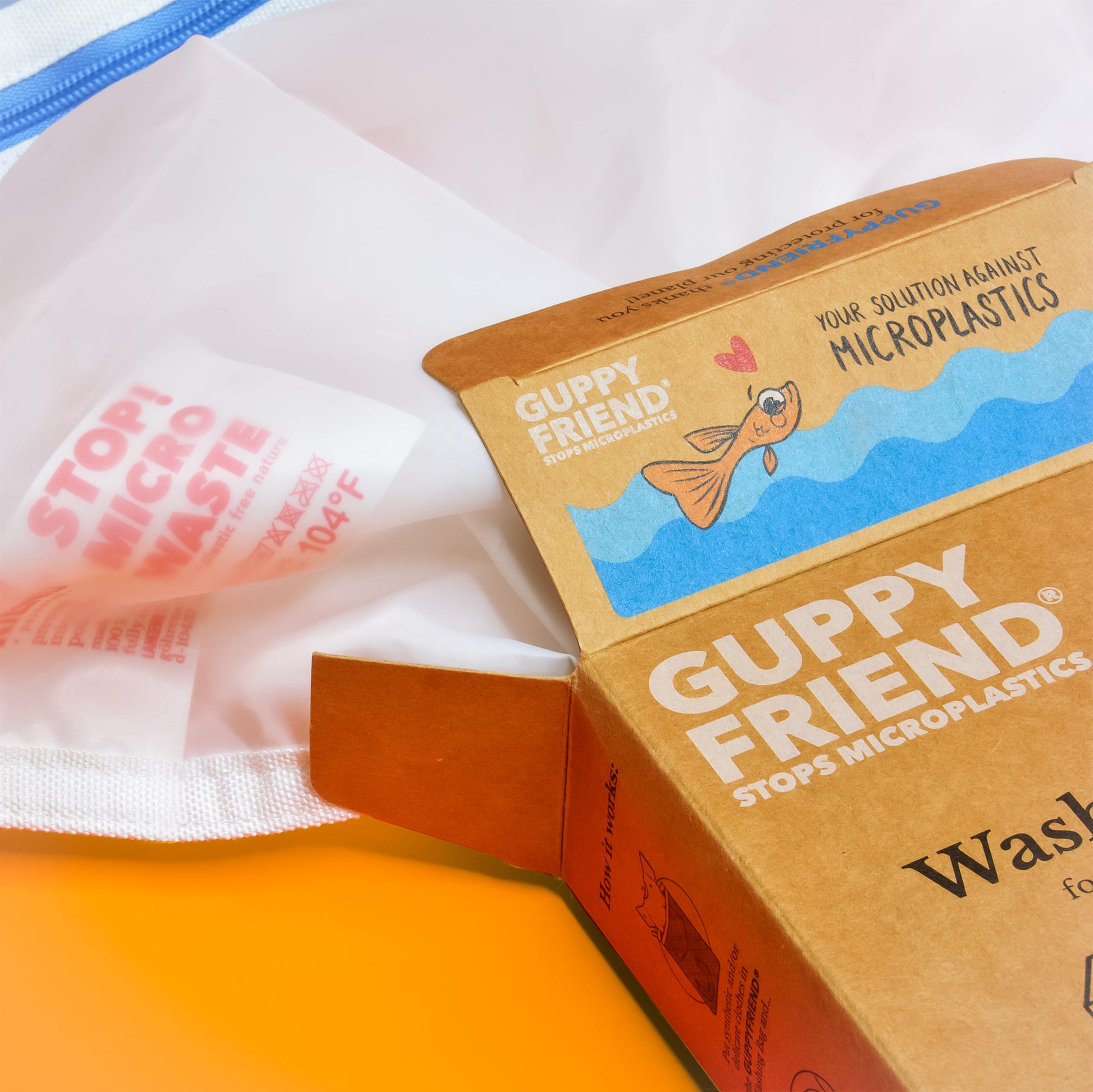 A close up of Guppyfriend packaging showing a fish and the words "your solution against microplastics"