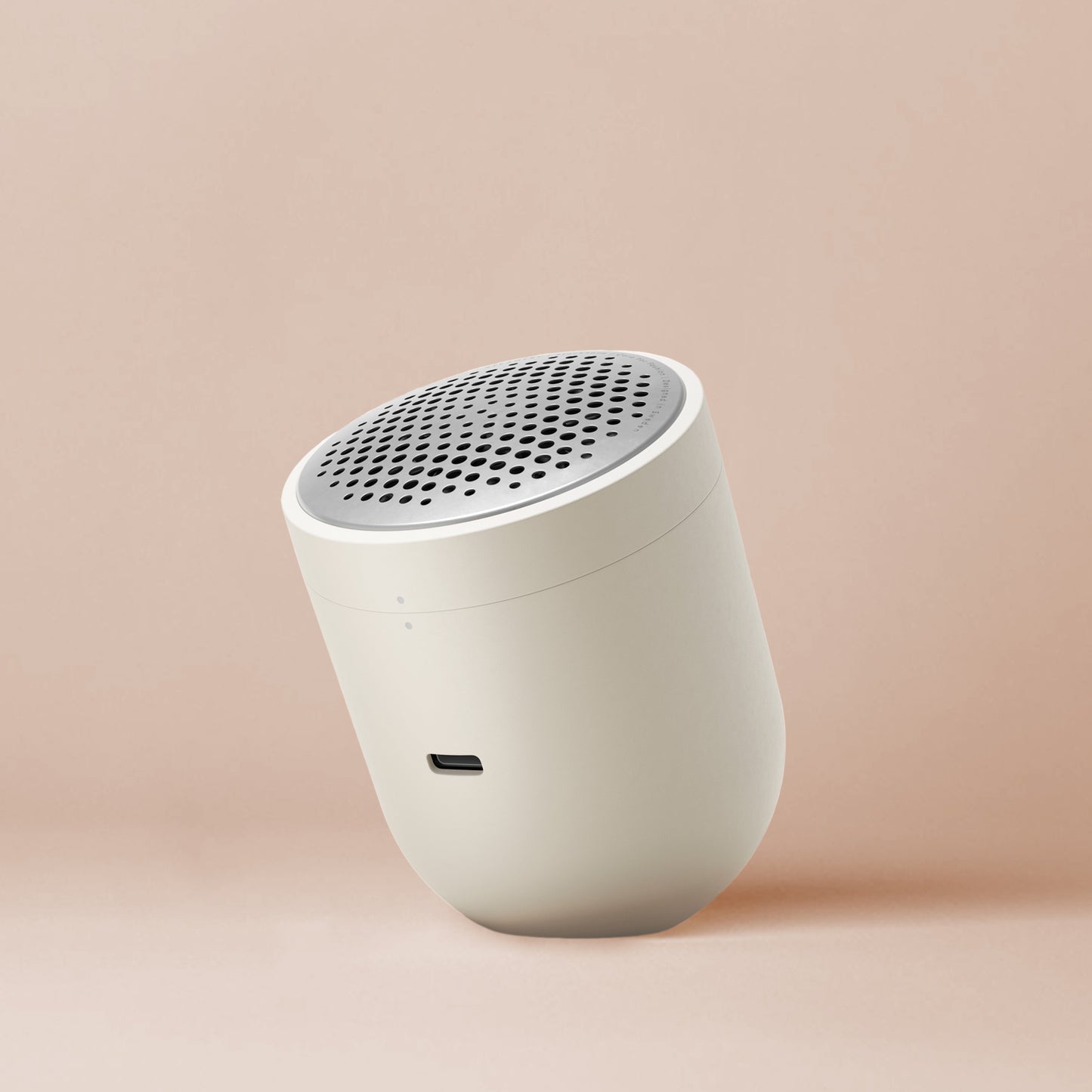 A dome shaped Pilo 2 fabric shaver in ivory sits at an elegant angle