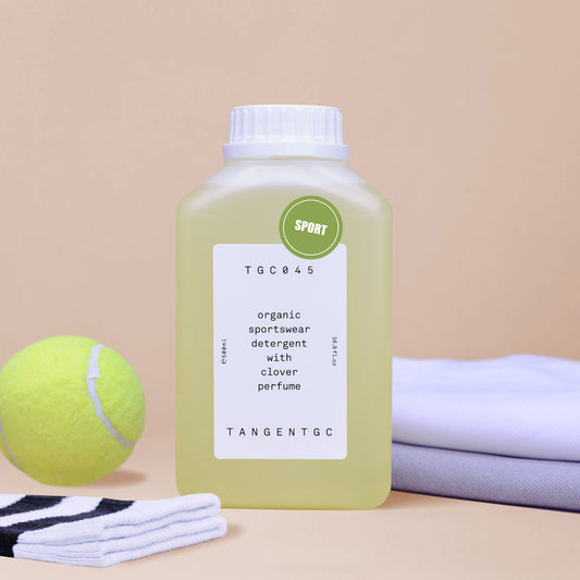 A bottle of sportswash displayed with a tennis ball and gym socks