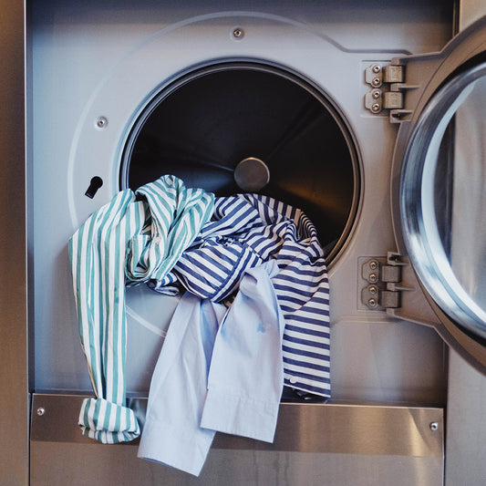 Button down shirts hanging out of a washing machine