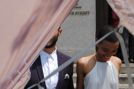 A newly wedded couple with faces obscured by balloons