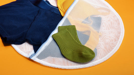 A pair of green baby socks placed on a wash bag for delicates