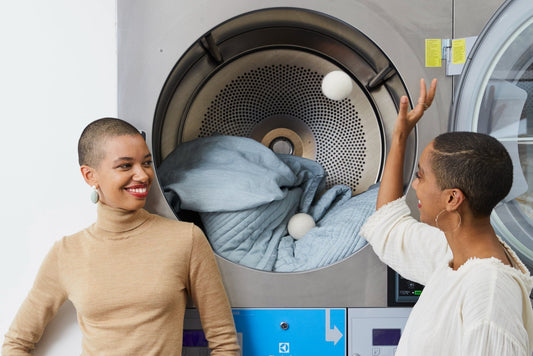 Theresa and Corinna Williams throw dryer balls into a dryer