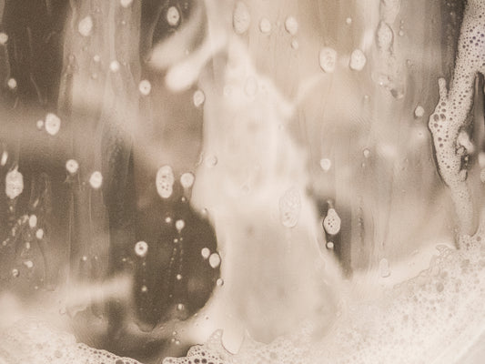 Soap suds run down the door of a front loading washing machine