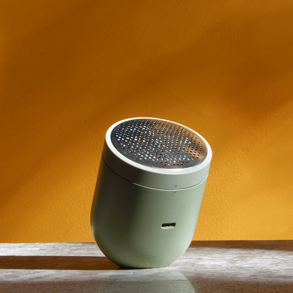 Steamery's Pilo 2 fabric shaver in their newest color sage, in afternoon light