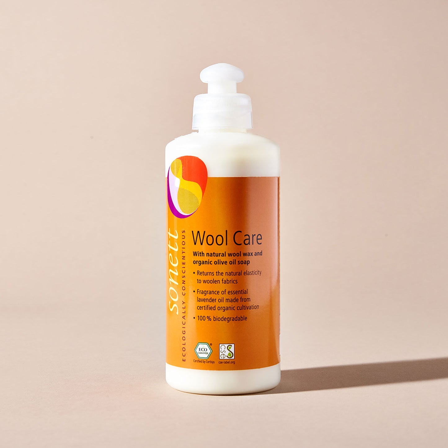 Sonett eco-friendly wool conditioner in a white squirt bottle with an orange label, displayed with a beige backdrop