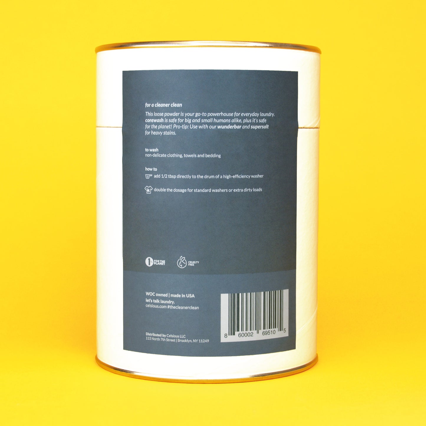 The back of a white can of unscented laundry powder by Celsious with a blue label showing usage instructions and product barcode; the can is displayed on a yellow backdrop