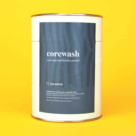 A white can of unscented laundry powder by Celsious with a blue label that reads "corewash" followed by ingredient info; the can is displayed on a yellow background